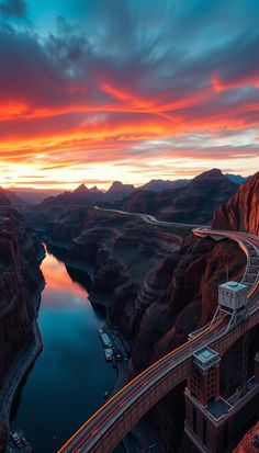 an aerial view of a highway going over a canyon at sunset with the sun setting in the distance