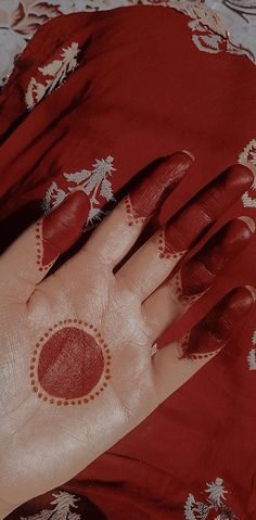 a woman's hand with red and white designs on it