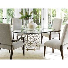 a glass table with chairs around it and a vase on the top of one chair