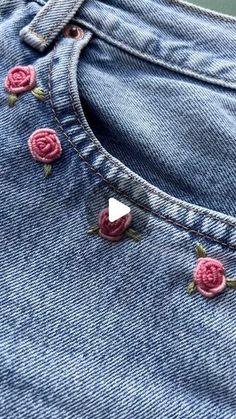 a pair of jeans with pink roses on them