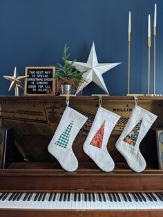 christmas stockings hanging on the piano keys