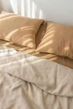 an unmade bed with two pillows on it