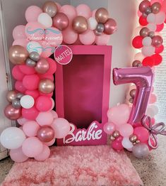 a pink and silver balloon arch with the number five on it for a first birthday