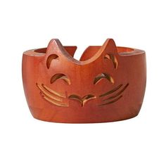 a wooden bowl with a cat's face carved into the front and side of it