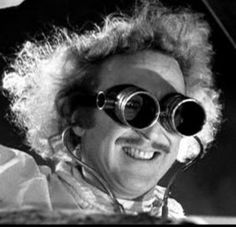 a man with curly hair wearing large binoculars