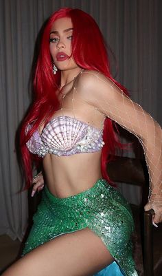 a woman with red hair wearing a mermaid costume