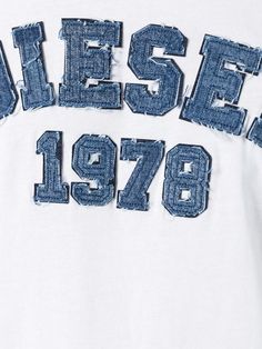 the back of a white t - shirt with blue letters and numbers printed on it