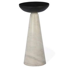 a black and white marble pedestal with a bowl on the top that sits in front of it