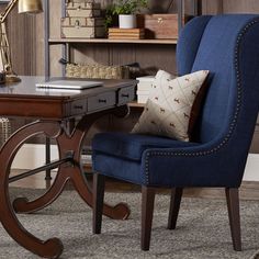 a blue chair sitting in front of a desk with a lamp on top of it