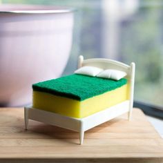 a miniature bed sitting on top of a table next to a bowl