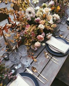 the table is set with flowers and place settings