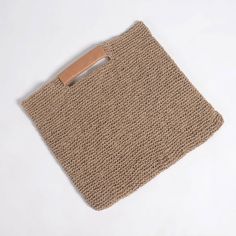 a crocheted bag with a wooden handle on a white surface, top view