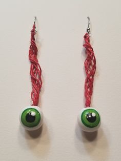 two green eyes are attached to red string