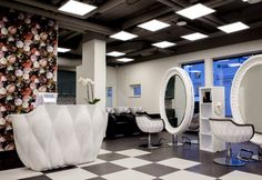 a salon with chairs, mirrors and flowers on the wall