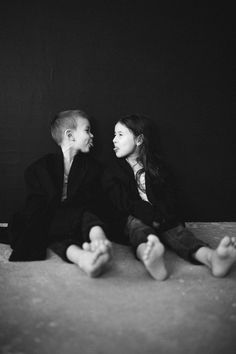 black and white photograph of two people sitting on the floor