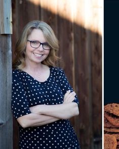 a woman standing next to a stack of chocolate chip cookies and smiling at the camera