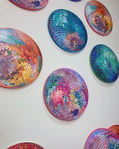 several colorful mosaic plates hanging on a wall