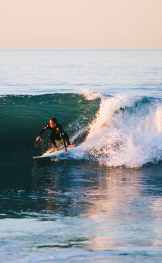 a man riding a wave on top of a surfboard in the middle of the ocean