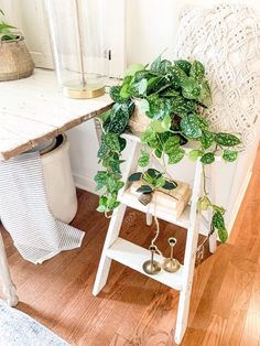 a white chair sitting next to a table with a potted plant on it