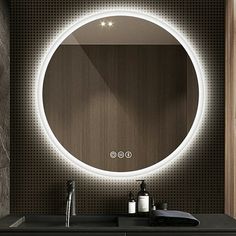 a bathroom sink with a lighted mirror above it