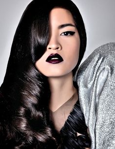 a woman with long black hair and dark lipstick