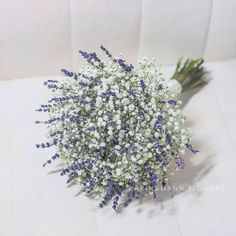 a bouquet of baby's breath sitting on top of a white cloth covered table