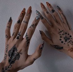 two hands with tattoos on them are next to each other