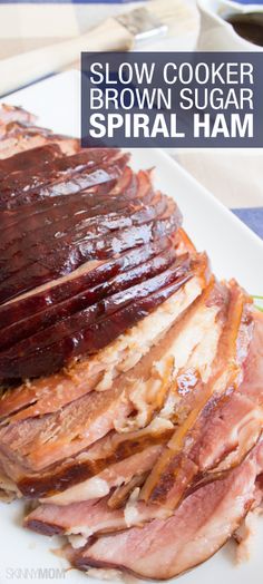 sliced ham on a white plate with brown sugar and syrup in the background text reads slow cooker brown sugar spiral ham