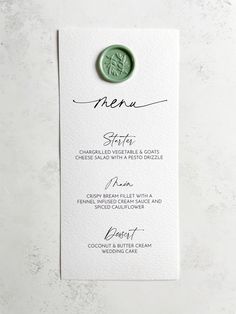 a menu card with a green wax seal on it and the word menu written in cursive writing