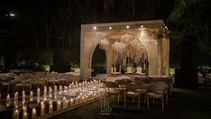 an outdoor wedding setup with candles and chandeliers