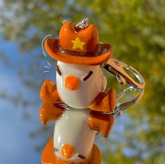 an orange and white snowman keychain with a star on it's hat