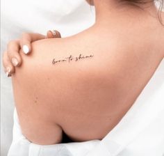 the back of a woman's shoulder with a tattoo saying born to shine on it