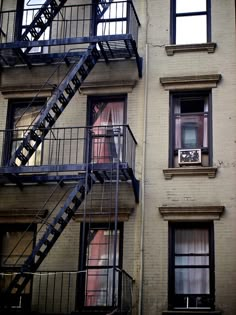 an apartment building with fire escape stairs leading up to the second floor