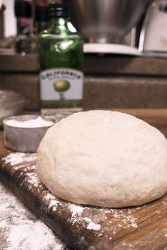 a ball of dough sitting on top of a wooden cutting board