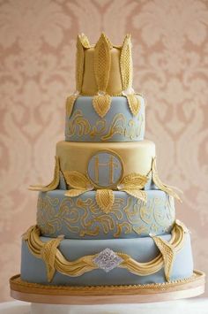 a three tiered blue and gold wedding cake