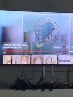 a flat screen tv mounted to the side of a wall next to a christmas wreath