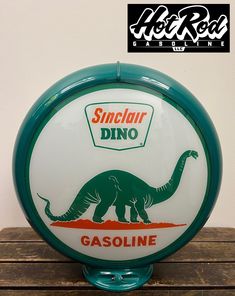 a green and white gas station sign with an image of a dinosaur on the front