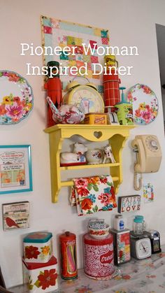 a table topped with plates and cups next to a wall covered in magnets on it