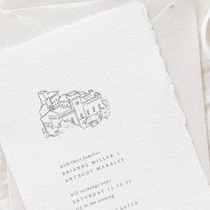 the wedding stationery is laid out on top of white paper and has a drawing of a castle