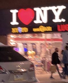 people are walking in front of i love ny store