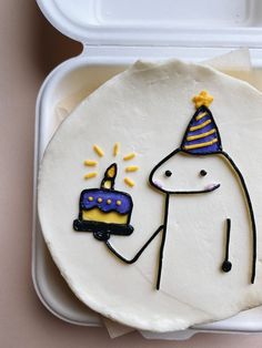 a birthday cake in a plastic container with a drawing of a person holding a lit candle