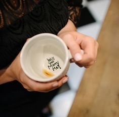 a woman holding a coffee cup with writing on it that says will you eat?