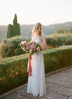 a woman in a white dress holding a bouquet of flowers