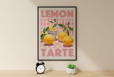 a lemon tarte poster hangs on the wall next to a clock and potted plant