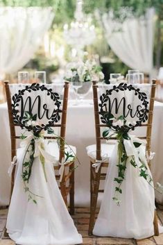 the chairs are decorated with flowers and monogrammed sashes for their guests to sit in