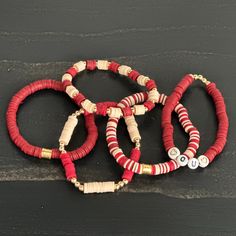 Are you a true Oklahoma fan? Show off your Sooner pride wherever you go with this spirited Oklahoma Sooners bracelet set! Each of these 5 stretchy beaded bracelets dazzle with team colors: crimson and cream. These beautiful handmade bracelets are the perfect accessory for any game day outfit or to accessorize any casual weekend look. Boomer Sooner! No matter where your loyalties lie, these gorgeous accessories will show your support for Norman and Oklahoma University in an irresistible way. Repr Red Heishi Beads Friendship Bracelets As Gift, Red Stacked Beaded Bracelets As Gift, Red Stacked Beaded Bracelets For Gifts, Red Heishi Beads Jewelry With Letter Beads, Handmade Red Stretch Bracelet With Heishi Beads, Red Heishi Bead Jewelry With Letter Beads, Adjustable Red Heishi Beads Stretch Bracelet, Red Adjustable Heishi Beads Stretch Bracelet, Red Beaded Bracelets With Letter Beads For Game Day