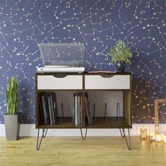 a record player on top of a shelf next to a wall with stars painted on it