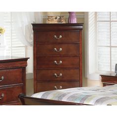 a bedroom scene with focus on the chest of drawers and the bed in the foreground