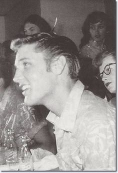 black and white photograph of people sitting at a table with drinks in front of them