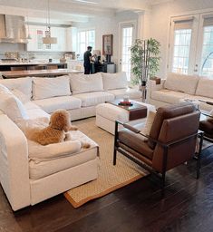 a living room filled with furniture and a brown dog sitting on the couch in front of it